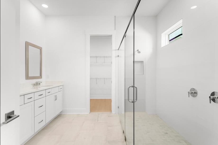 Lavish primary bathroom with a large walk-in shower and dual-sink vanity