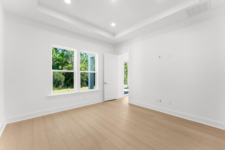 First-floor primary bedroom suite with tray ceilings