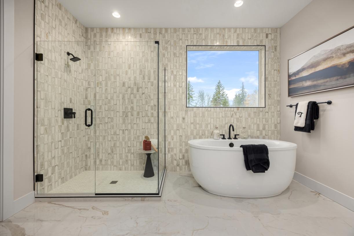 Luxe primary bathroom features a walk-in shower with frameless glass enclosure