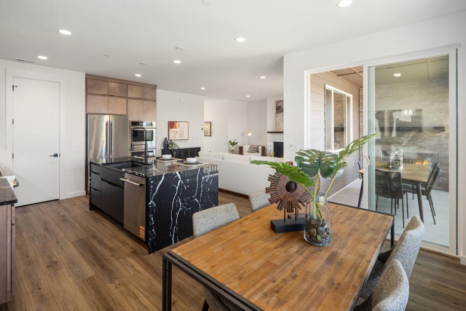 Sliding patio doors off of the casual dining area open to covered patio with outdoor gas fireplace