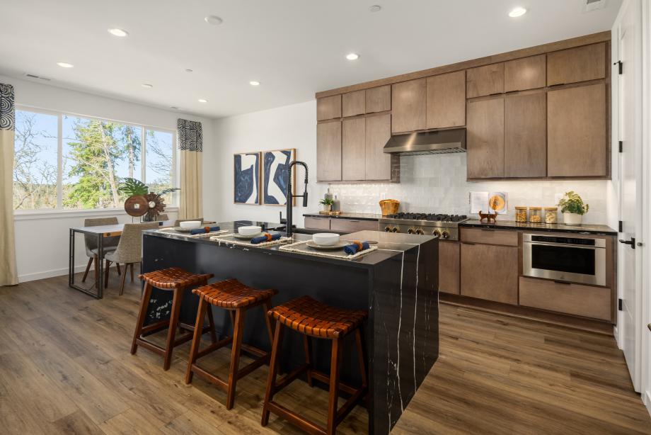 Kitchen island features a stunning black quartz countertop with double-waterfall edges
