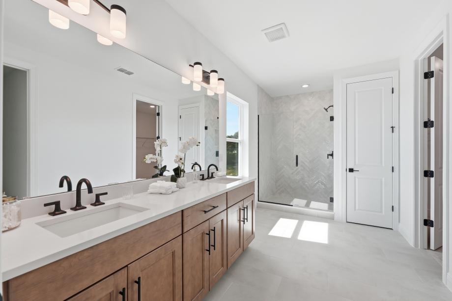 Primary suite featuring a spacious walk-in closet and a spa-like primary bath