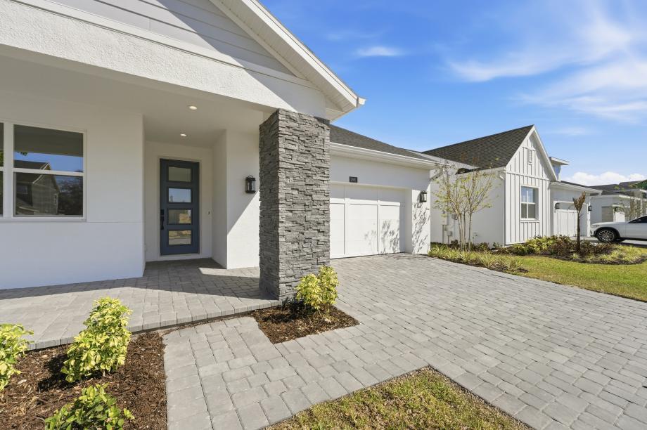 The inviting covered front porch sets a sophisticated tone framed by professional landscaping
