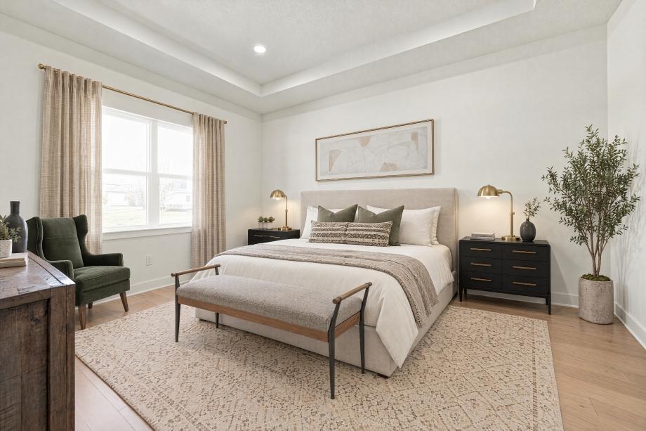Elegant primary bedroom suite with tray ceiling and generous natural light