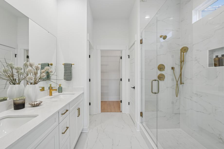 Spa-like primary bathroom with dual-sink vanity, luxe walk-in shower, and private water closet
