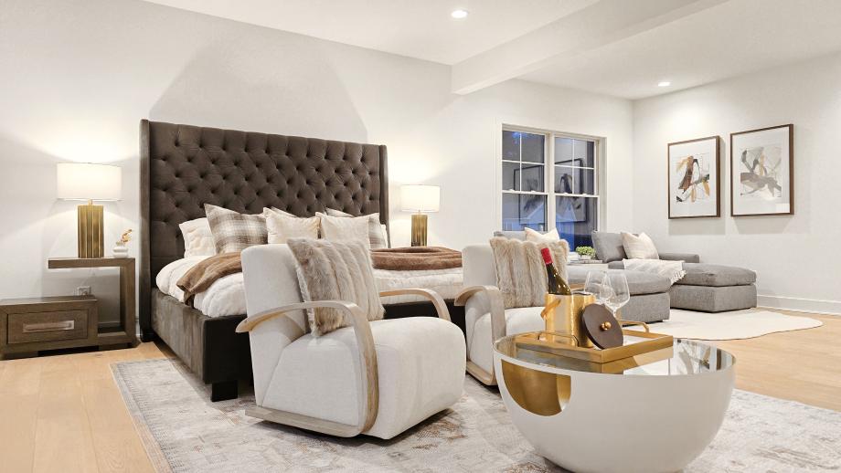 Serene primary bedroom suite with sitting area, dual walk-in closets, and workspace