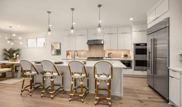 Kitchen features double-stacked contemporary white flat panel cabinetry