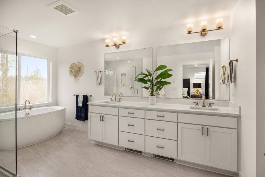 Primary bathroom with dual-sink vanity and a freestanding tub