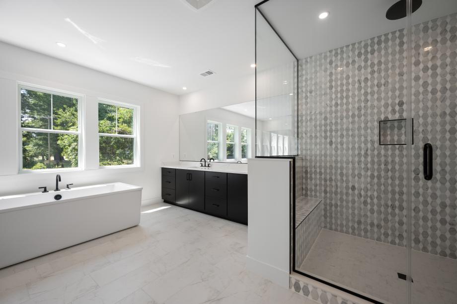 Luxurious primary bathroom with freestanding tub and shower with seat