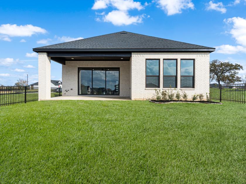 Expansive backyard with ample green space and covered patio