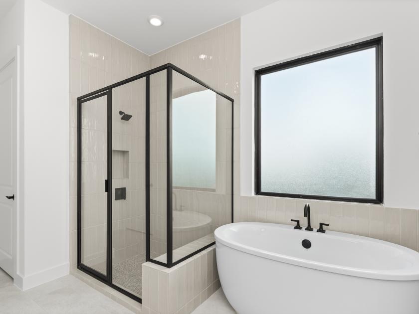 Spa-inspired primary bathroom with dual vanities, oversized shower and freestanding soaking tub