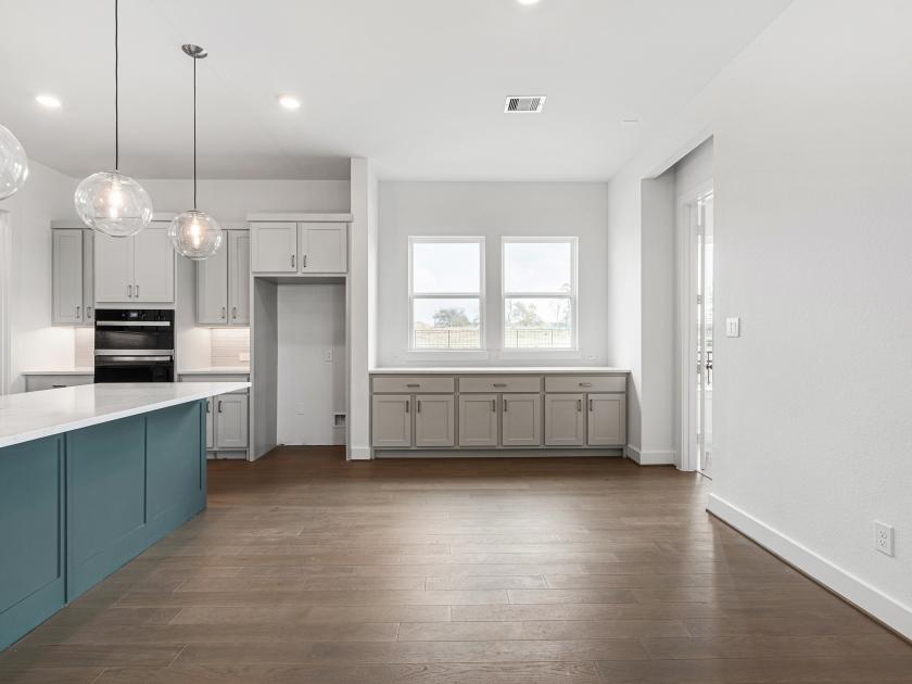 Kitchen with pendant lighting, spacious island, and additional cabinet space