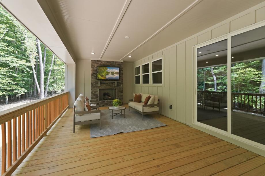 Spacious covered outdoor living area with a cozy fireplace for year-round enjoyment