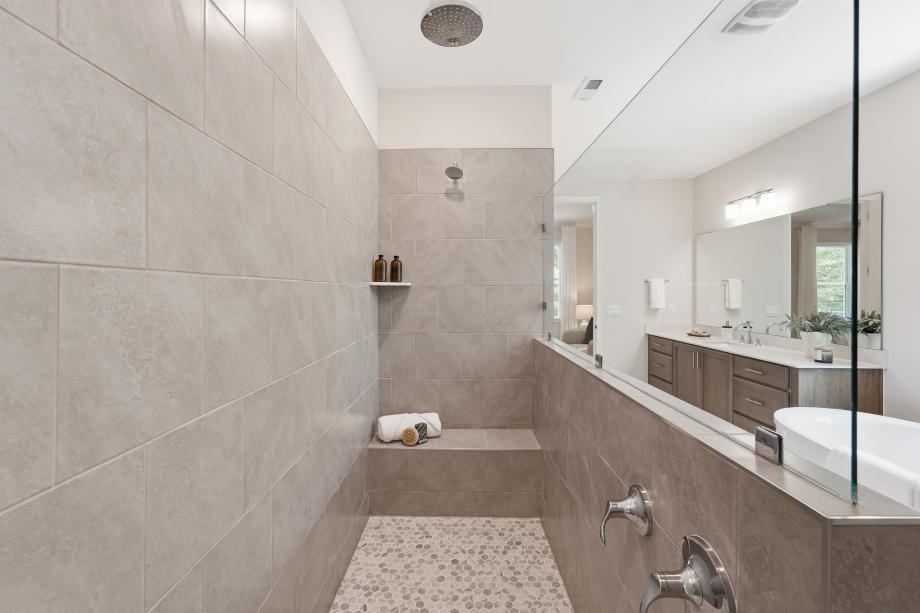 Generous walk-in shower featuring a convenient built-in seat