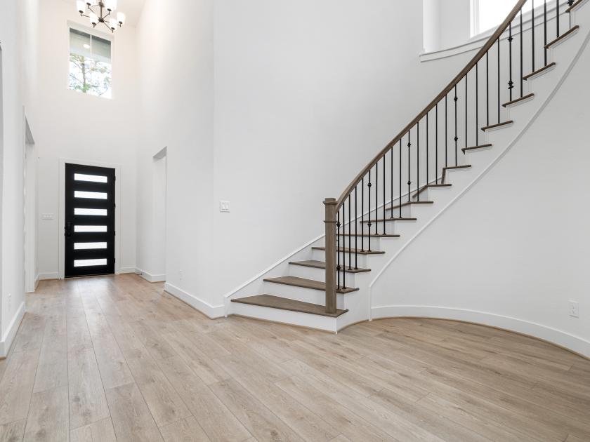 Expansive foyer with generous ceiling heights and elegant curved staircase