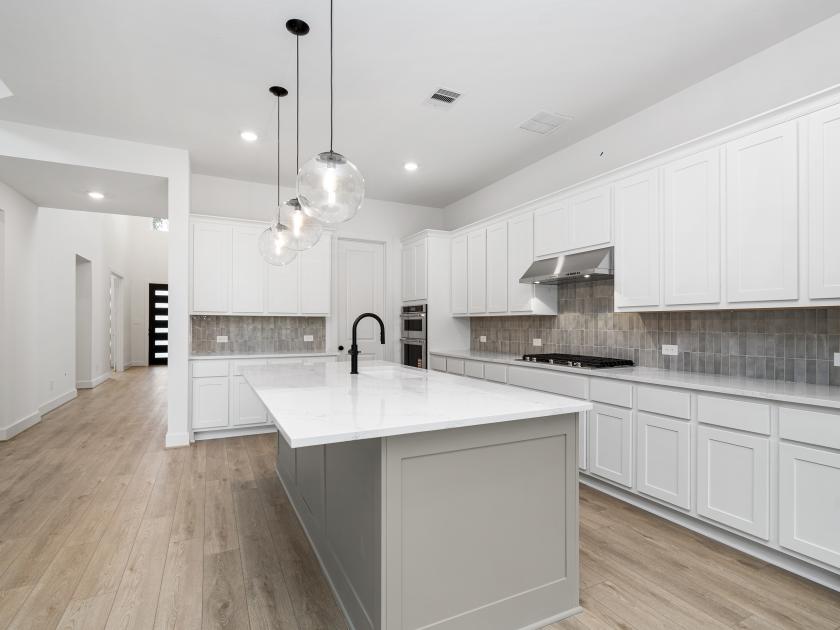 Gourmet kitchen with two-tone cabinetry, spacious island, and premium stainless steel appliances