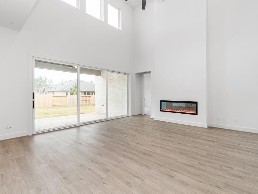 Great room set against a wall of sliding doors designed to maximize natural light and backyard views
